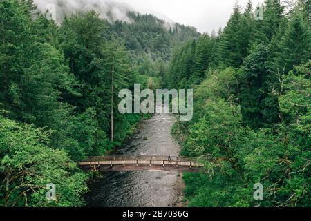 Ein junges Paar genießt eine Wanderung auf einer Brücke im Pazifischen Nordwesten. Stockfoto