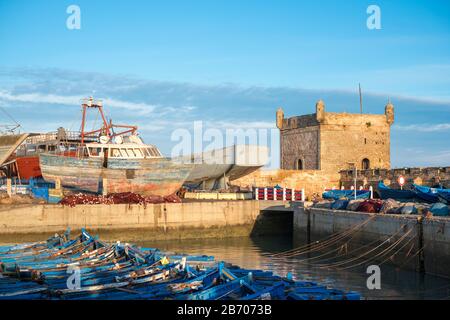 Marokko, Marrakesh-Safi (Marrakesh-Tensift-El Haouz) Region, Essaouira. Skala du Port, 18. Jahrhundert Küste Stadtmauern und Boote im Hafen. Stockfoto