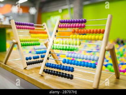 Kinderholzabakusspielzeug in heller Farbe auf dem Hintergrund des Spielraums. Umweltfreundliches Spielzeug Stockfoto