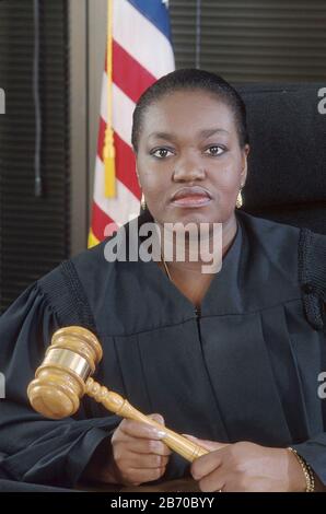 Austin Texas USA, 1997:die afroamerikanische Bezirksrichterin sitzt in schwarzer Robe an ihrer Bank und hält einen Gavel. HERR ©Bob Daemmrich Stockfoto