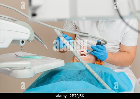 Der Patient besucht den Zahnarzt bezüglich des Verfahrens der Ultraschallreinigung von Zähnen in der Zahnmedizin.2020 Stockfoto
