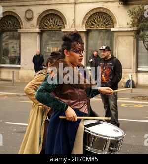 Rijeka, Kroatien, 23. Februar 2020. Schlagzeugerin. Attraktive schöne maskierte Schlagzeugerin, die langsam auf der Straße läuft und auf dem Carn Trommel spielt Stockfoto