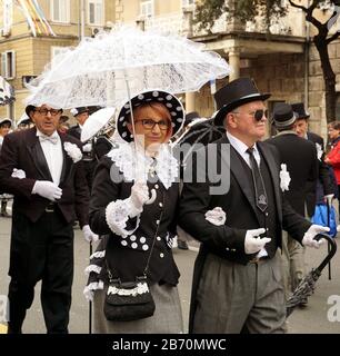 Rijeka, Kroatien, 23. Februar 2020. Älteres Paar in festlicher Aristokratie schwarz-weiße Outfits im Karnevalszug, der auf der Straße spazieren geht Stockfoto