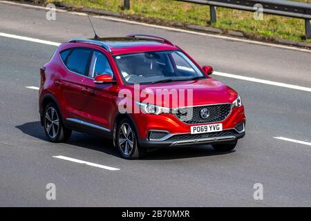 2019 Red MG ZS Exclusive EV; UK Vehicular Traffic, Transport, moderne Fahrzeuge, Salonwagen, bewegte Fahrzeuge, Fahrzeuge, Straßen, Motoren, Fahren auf der Autobahn M6 Stockfoto