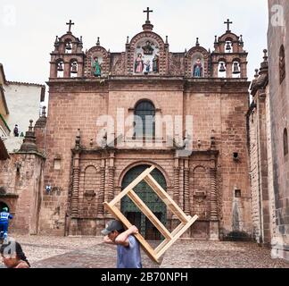 Mann mit Möbeln vor dem Tempel der Heiligen Familie Cusco, Peru Stockfoto