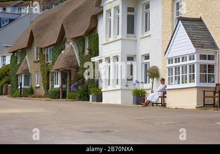 Dame, die sich vor einem Strandferienhaus in St. Mawes, SüdCornwall, entspannen kann Stockfoto