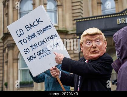 Mann in einer Donald Trump-Maske, die Kinder für den Schulstreik auf dem Greta Thunberg Marsch zum Klima in Bristol UK anmahnen lässt Stockfoto