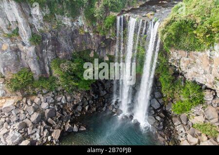 Luftbild des Hohen Wasserfalls Jeongbang und Lagune auf der Insel Jeju, Südkorea. Stockfoto