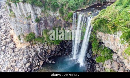 Luftbild des Hohen Wasserfalls Jeongbang und Lagune auf der Insel Jeju, Südkorea. Stockfoto