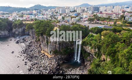 Luftbild des Hohen Wasserfalls Jeongbang, Lagune und Seoqwipo auf Jeju-Insel, Südkorea. Stockfoto