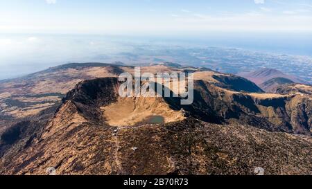 Luftbild des Hallasan-Gebirges auf der Insel Jeju, Südkorea. See, Kratertal und Hang des Vulkans. Stockfoto