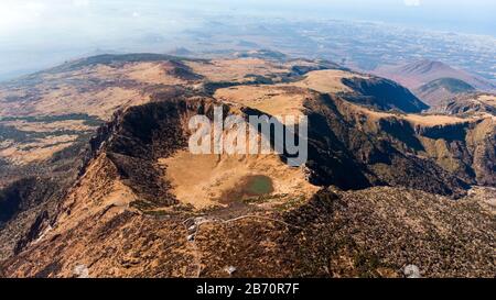Luftbild des Hallasan-Gebirges auf der Insel Jeju, Südkorea. See, Kratertal und Hang des Vulkans. Stockfoto