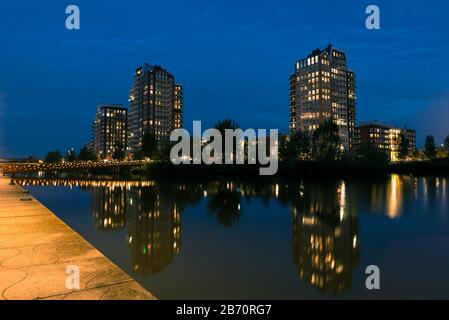Reflexionen im Wasser der Skyline von Quarter Oosterheem in der Stadt Zoetermeer, Niederlande während der blauen Stunde Stockfoto