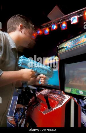 Austin Texas USA: 13-jähriger Junge spielt gewalttätiges Videospiel in der Arcade. HERR ©Bob Daemmrich Stockfoto