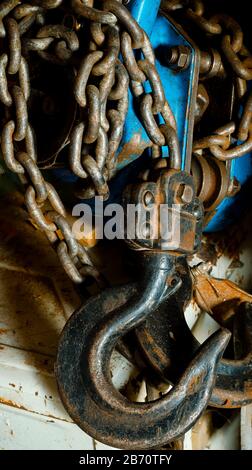 Nahaufnahme des gebrauchten manuellen Hubwerks. Ein rostiges Handwerkzeug liegt auf einer Werkbank. Hebeausrüstung. Selektiver Fokus. Aufnahmen auf Augenhöhe. Stockfoto