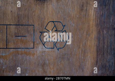 Recycling-Schild auf Holzhintergrund. Spanplatte mit Verpackungssymbol. Alte Mailbox aus Sperrholz. Gerissene Holzstruktur. Logistikdienstleistungen. Selektive Fokussierung Stockfoto