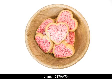 Herzförmige Plätzchen in einer Holzschale auf weißem Grund Stockfoto