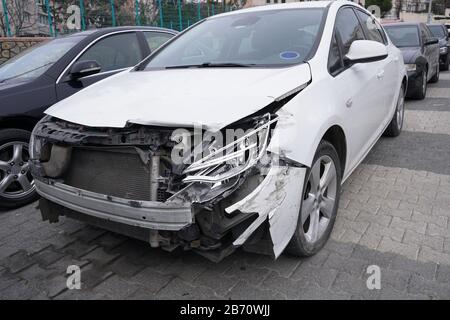 Ein geparktes Fahrzeug stürzte auf der Straße mit gebrochenen Scheinwerfern und Vorderansicht ab Stockfoto