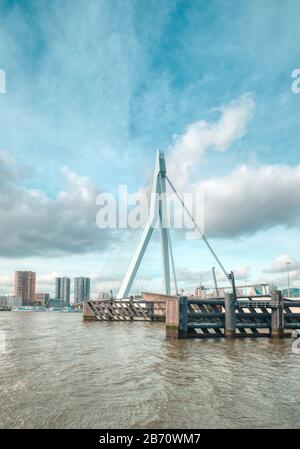 Rotterdam - 12. Februar 2019: Rotterdam, die Skyline der niederländischen Innenstadt in der Dämmerung in Südholland, Rotterdam, Niederlande. Pfähle im Wasser davor Stockfoto
