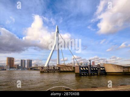 Rotterdam - 12. Februar 2019: Rotterdam, die Skyline der niederländischen Innenstadt in der Dämmerung in Südholland, Rotterdam, Niederlande. Pfähle im Wasser davor Stockfoto