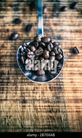 Löffel auf einem Tisch mit Kaffeebohnen Stockfoto
