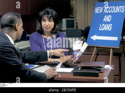 Austin Texas USA: Junge spanische Bankbeamtin diskutiert mit schwarzem männlichen Kunden bei der Bank der Bank über Verbraucherkredite. HERR ©Bob Daemmrich Stockfoto