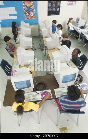 Austin, Texas, USA: Schüler der vierten Klasse, die Apple-Computer und Apple-Computer-Lese- und Mathematikprogramme im Computerlabor der Schule nutzen. ©Bob Daemmrich Stockfoto