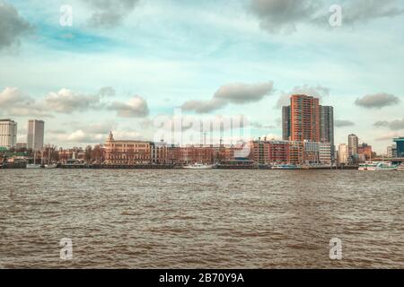 Rotterdam - 12. Februar 2019: Rotterdam, die Skyline der niederländischen Innenstadt in der Dämmerung in Südholland, Rotterdam, Niederlande. Rechts die Erasmus-Brücke Stockfoto