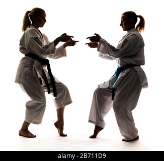 Starke junge blonde Mädchen trainieren im Kimono auf weißem Hintergrund. Junge Profi-Athleten. Stockfoto