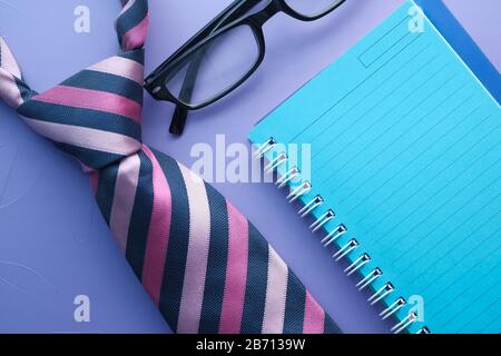 Fathers Day Konzept mit Krawatte, Notizblock und Brillenglas auf dem Tisch. Stockfoto