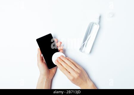 Handwischtelefon für Frauen mit alkoholdekontaminierender Mittel, Draufsicht auf weißem Hintergrund. Stockfoto