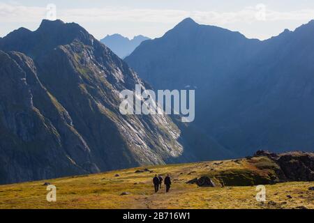 Blick auf die Berglandschaft im Norden von Norwegen, Lofoten, Nordland, auf dem Weg zur kvalvika Ryten Berge und Strand, mit Gruppen von Wanderer, ein Stockfoto