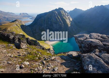 Blick auf die Berglandschaft im Norden von Norwegen, Lofoten, Nordland, auf dem Weg zur kvalvika Ryten Berge und Strand, mit Gruppen von Wanderer, ein Stockfoto