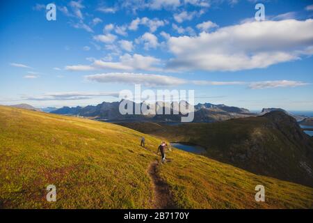 Blick auf die Berglandschaft im Norden von Norwegen, Lofoten, Nordland, auf dem Weg zur kvalvika Ryten Berge und Strand, mit Gruppen von Wanderer, ein Stockfoto