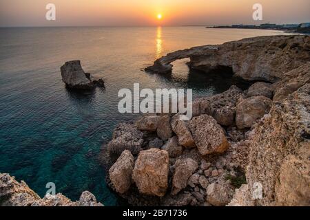 Wunderschöner Sonnenuntergang auf der Natursteinbrücke in der Nähe von Ayia Napa auf Zypern. Liebesbrücke. Cavo greco Stockfoto