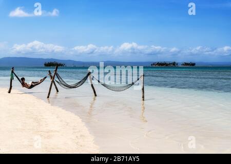 San Blas, Panama - 25. Februar 2020: Entspannung für Touristen in der Hängematte am wunderschönen einsamen Strand auf der karibischen Insel San Blas an der politisch autonomen Guna Stockfoto