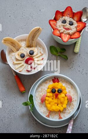 Lustige Schüsseln mit Haferflockenbrei mit Häschen, Küken und Blume für Ostern Stockfoto