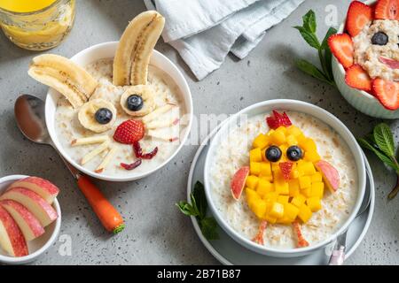 Lustige Schüsseln mit Haferflockenbrei mit Häschen, Küken und Blume für Ostern Stockfoto