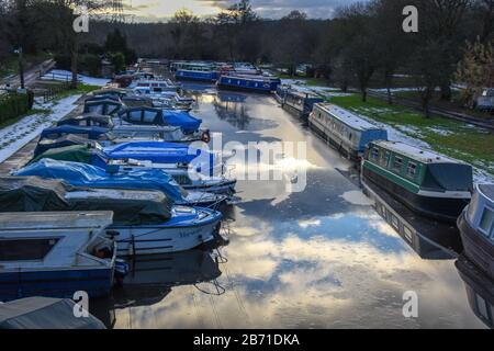 Blick auf eine Reihe von Wasserfahrzeugen an einem kalten Wintertag in einem Binnenhafen mit teilweise gefrorenem Wasser Großbritannien. Stockfoto