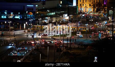 Berlin, Deutschland. März 2020. Abendblick auf den Alexanderplatz in Berlin Mitte. Eine Straßenbahn überquert die Alexanderstraße. In der Mitte ist der Eingang des Park Inn Hotels beleuchtet. Kredit: Annette Riedl / dpa-Zentralbild / ZB / dpa / Alamy Live News Stockfoto