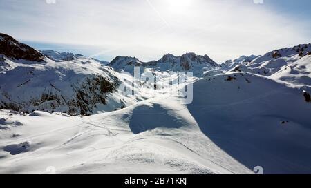 Luftbild der Alpen in Frankreich. Bergkuppen im Schnee bedeckt. Alpine Skianlagen von oben. Stockfoto