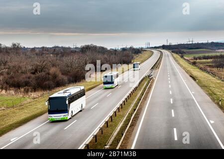 Drei Linienbusse fahren auf einer Landstraße Stockfoto