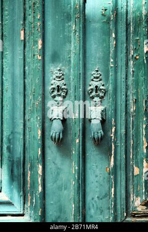 Türknocker mit Handform an der grünen Holztür in Lissabon, Portugal Stockfoto