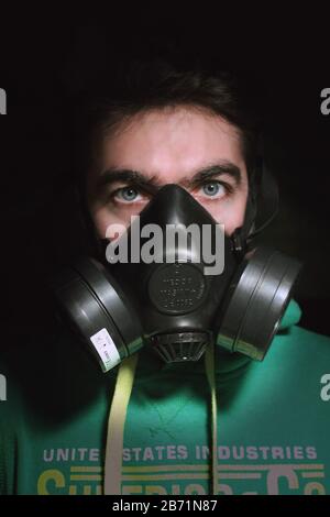 Europäischer kaukasischer Junge mit grünem Sweatshirt trägt eine Quarantänegasmaske, um sich in italien vor einer Coronavirus-Infektion zu schützen Stockfoto