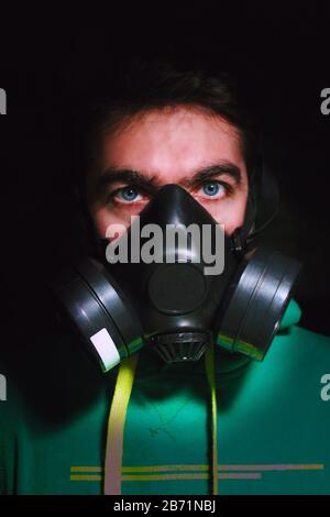 Europäischer kaukasischer Junge mit grünem Sweatshirt trägt eine Quarantänegasmaske, um sich in italien vor einer Coronavirus-Infektion zu schützen Stockfoto