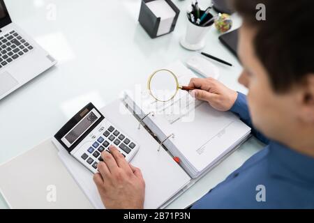 Geschäftsmann Dokument durch Lupe betrachten Stockfoto