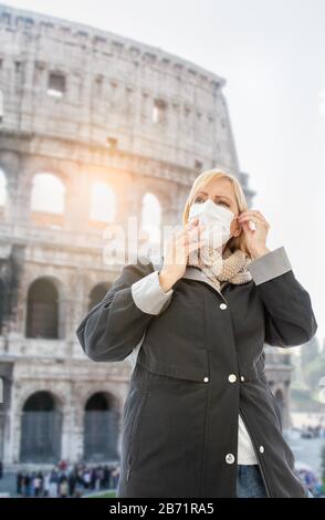 Junge Frau Mit Gesichtsmaske Spaziert in der Nähe des römischen Kolossums In Rom, Italien. Stockfoto