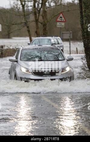 Überschwemmungen durch Storm Ciara an der Rothay Bridge in Ambleside, Lake District, Großbritannien, mit Autos durch die Überschwemmungen. Stockfoto