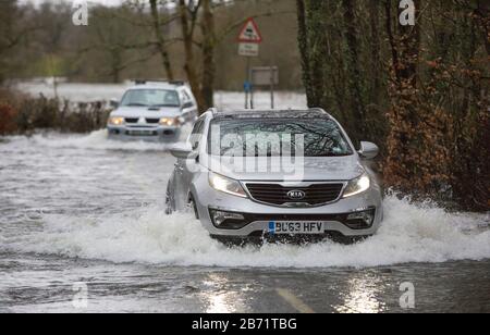 Überschwemmungen durch Storm Ciara an der Rothay Bridge in Ambleside, Lake District, Großbritannien, mit Autos durch die Überschwemmungen. Stockfoto