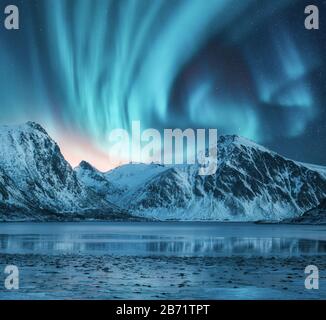 Nordlichter über schneebedeckten Felsen. Winterlandschaft Stockfoto